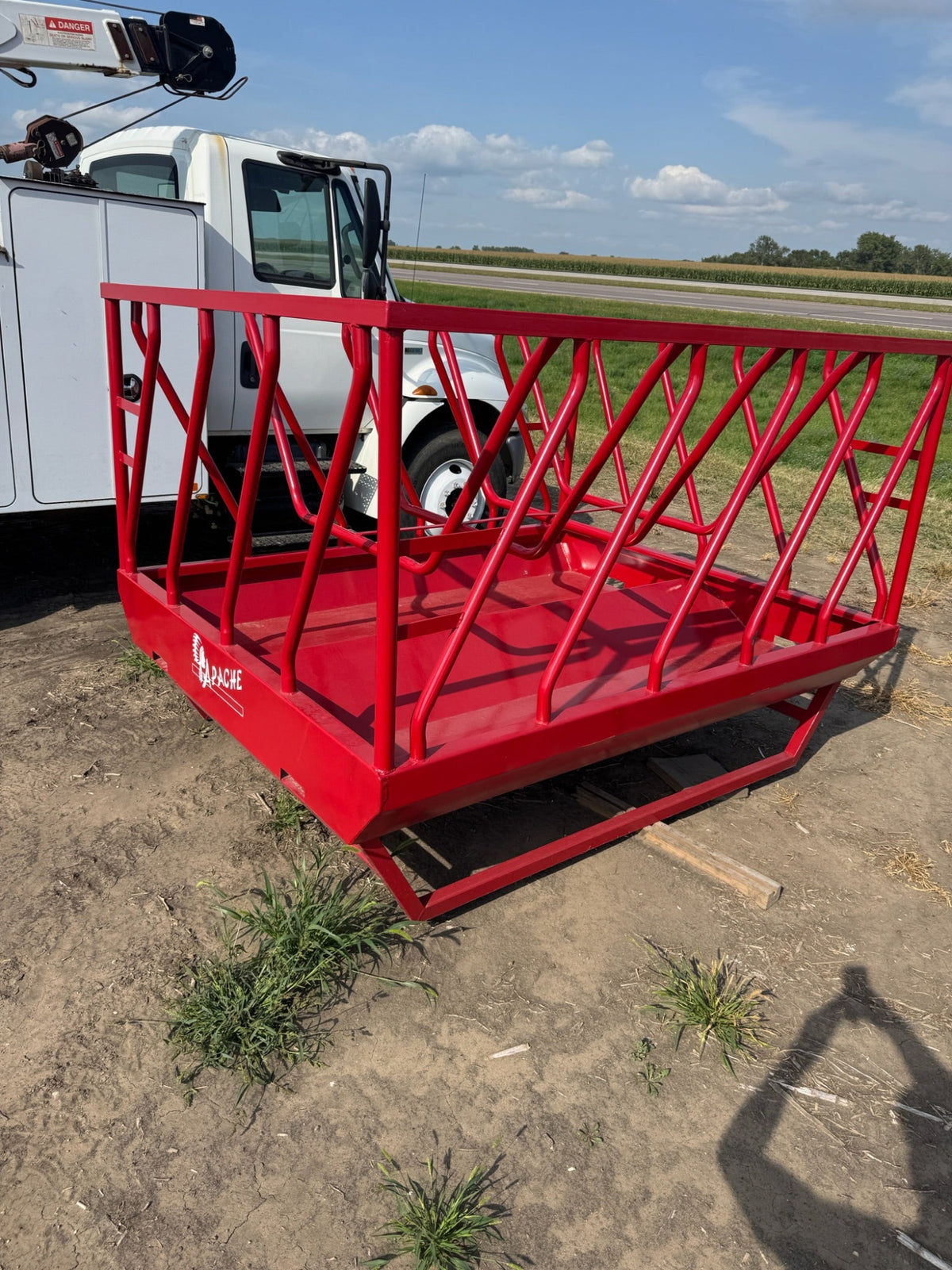 Red agricultural basket on a truck bed with a rural landscape in the background
