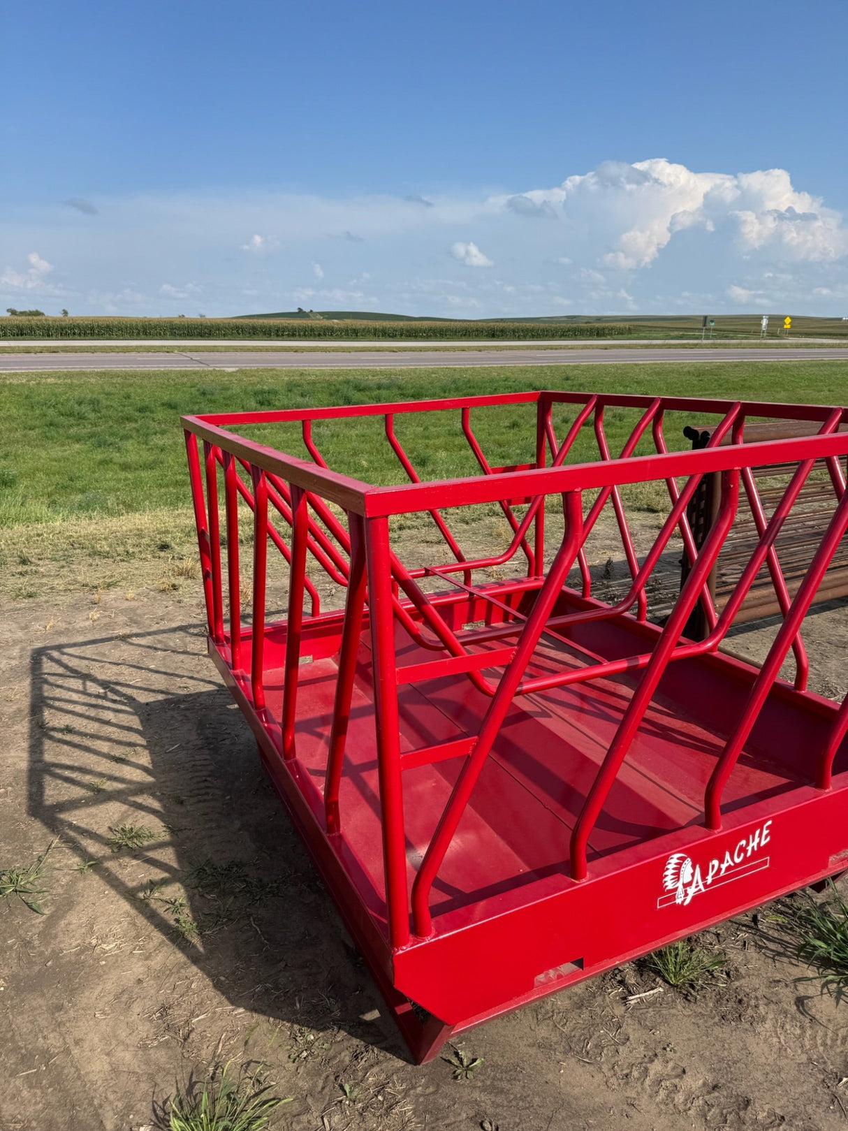 Red agricultural equipment on a dirt field with a clear sky