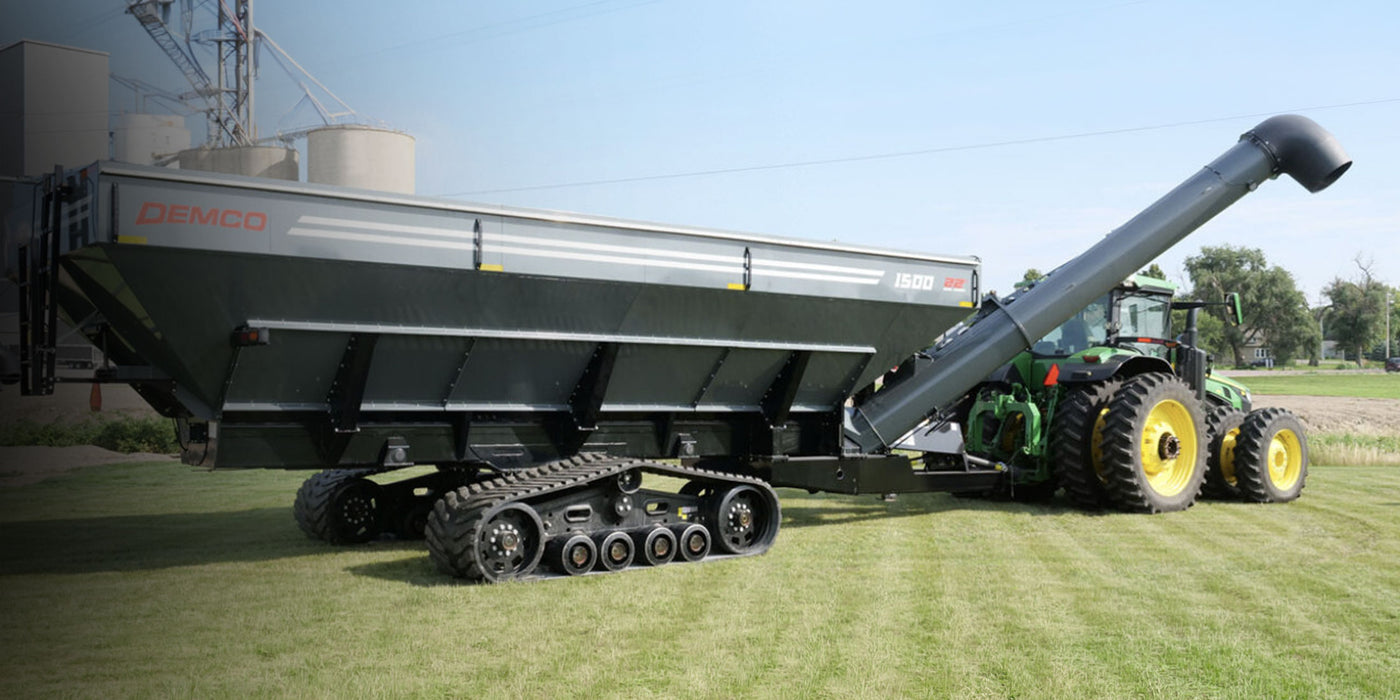 Large agricultural trailer with a tractor on a grassy field