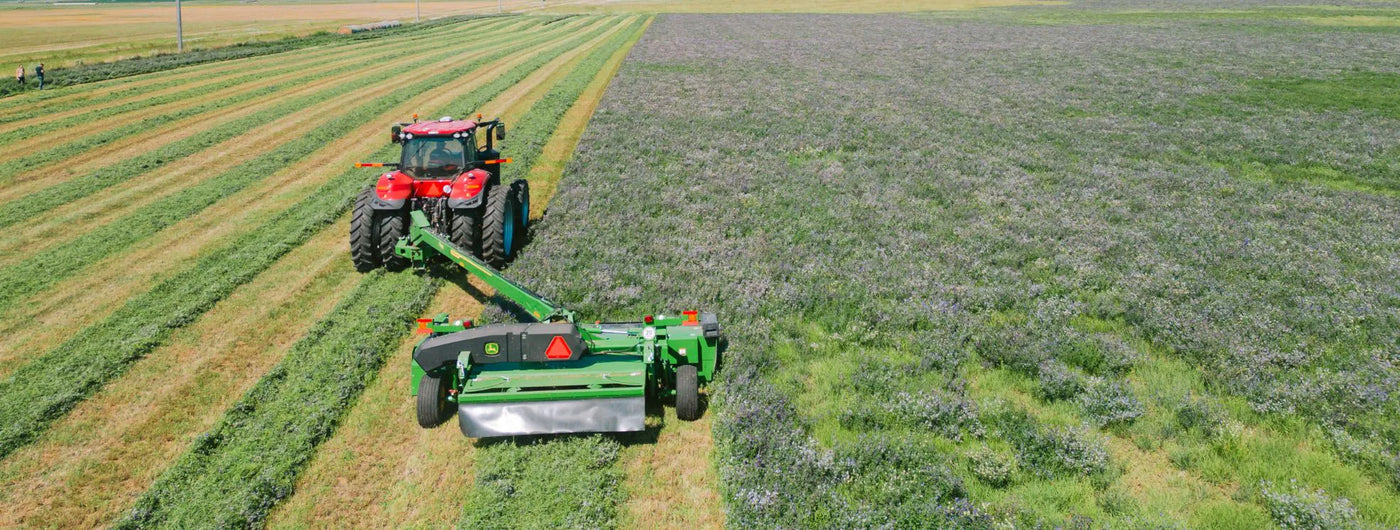 Tractor cutting alfalfa with the protection of a Rock Block.