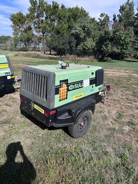 A green sullair air compressor with trees behind it