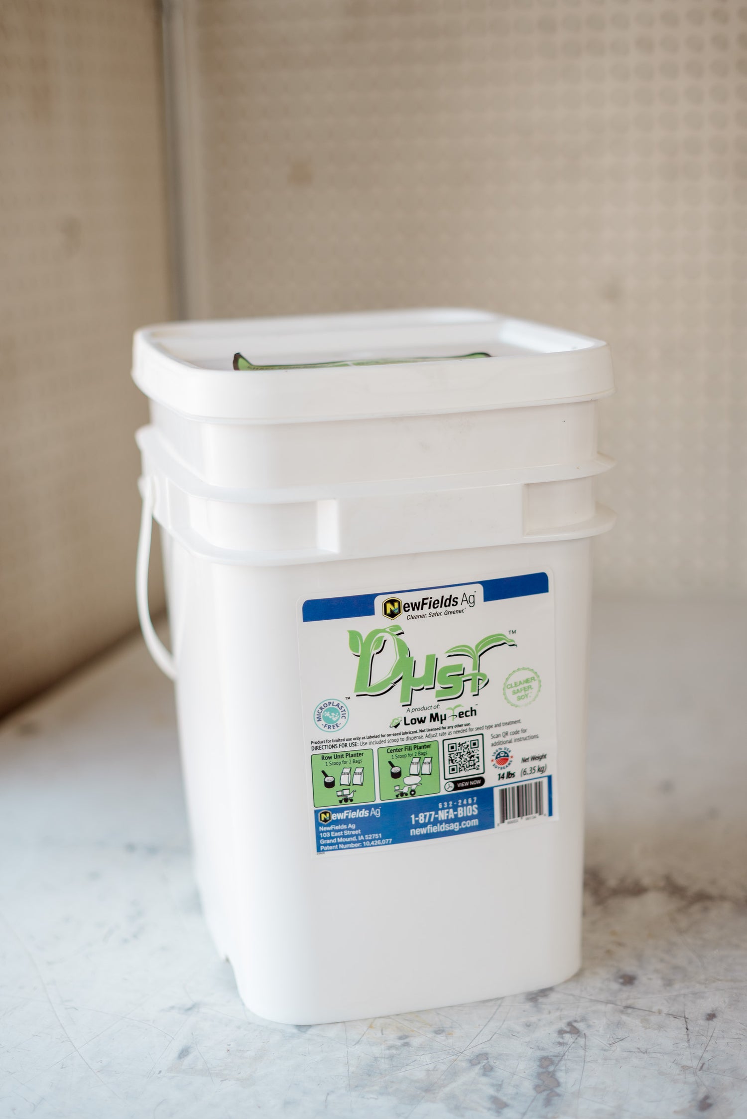 White bucket labeled 'Dust' on a marble surface with a neutral background